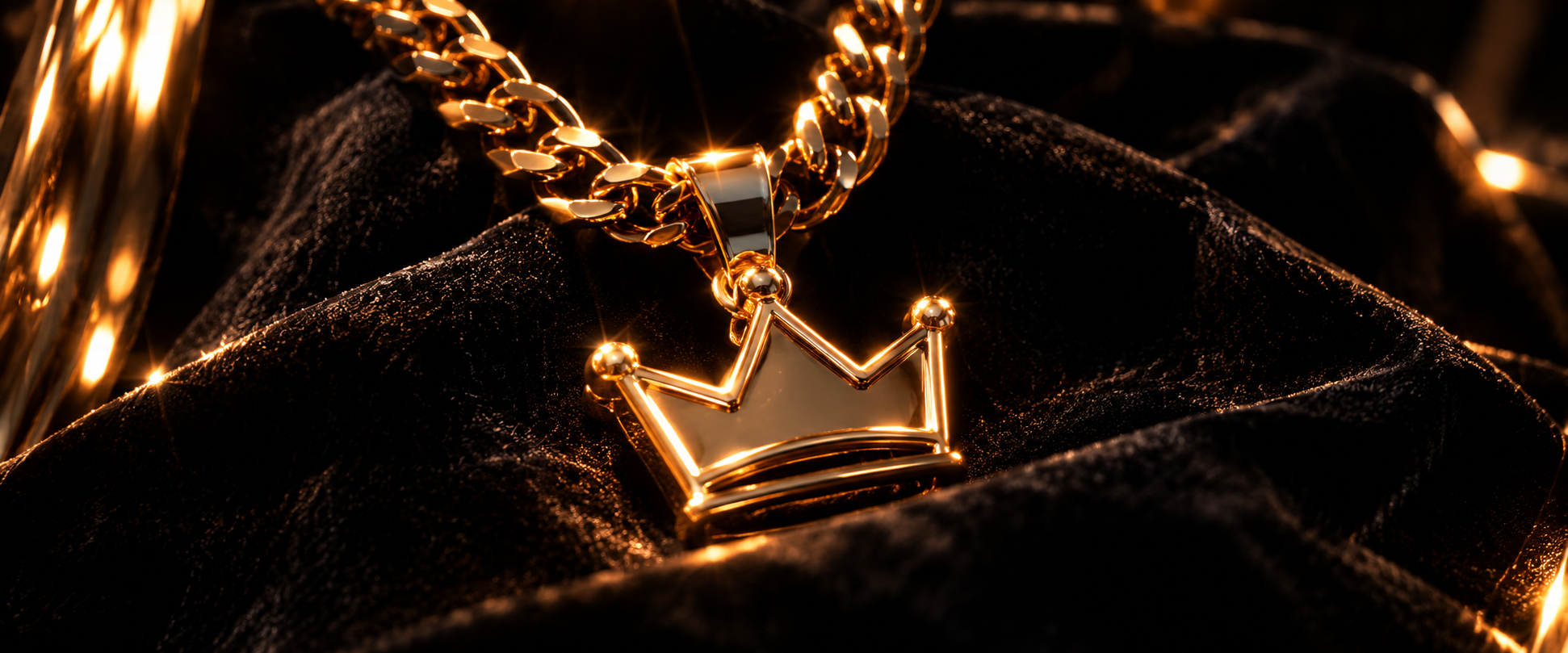 Golden crown pendant on a black fabric background